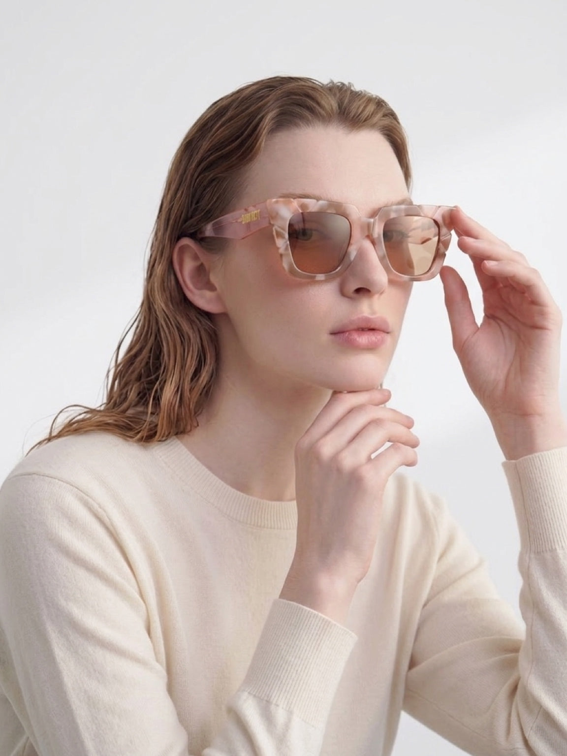Woman adjusting CONILVARO pink tortoiseshell-effect square sunglasses with brown gradient lenses