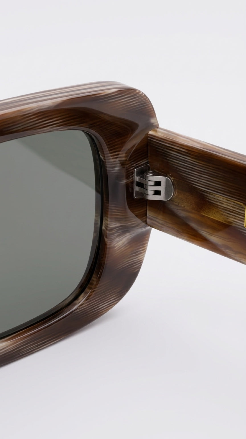 Close-up of CONFILVARO brown tortoiseshell-effect acetate frame, dark lens and metal hinge