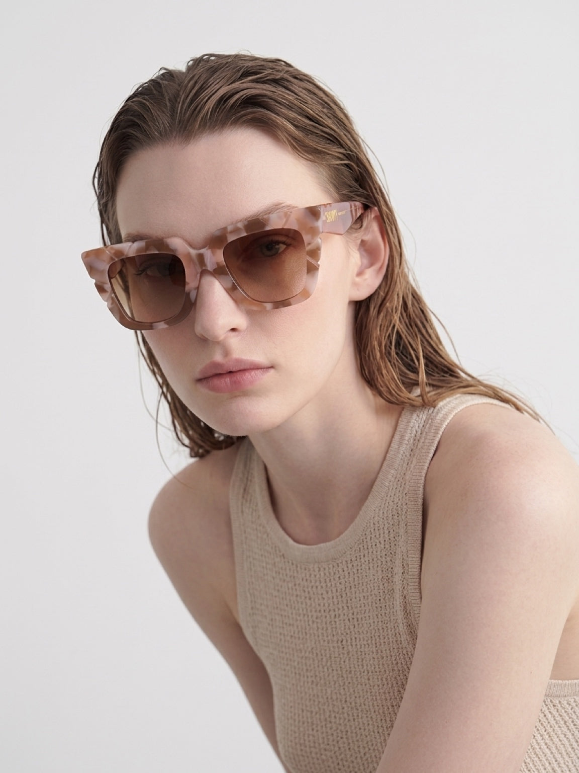 Close-up of woman wearing CONILVARO pink tortoiseshell-effect square sunglasses
