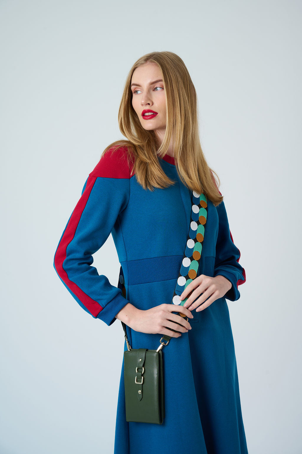 Model wearing CarryOn FRIDAY phone wallet bag in green leather with gold strap