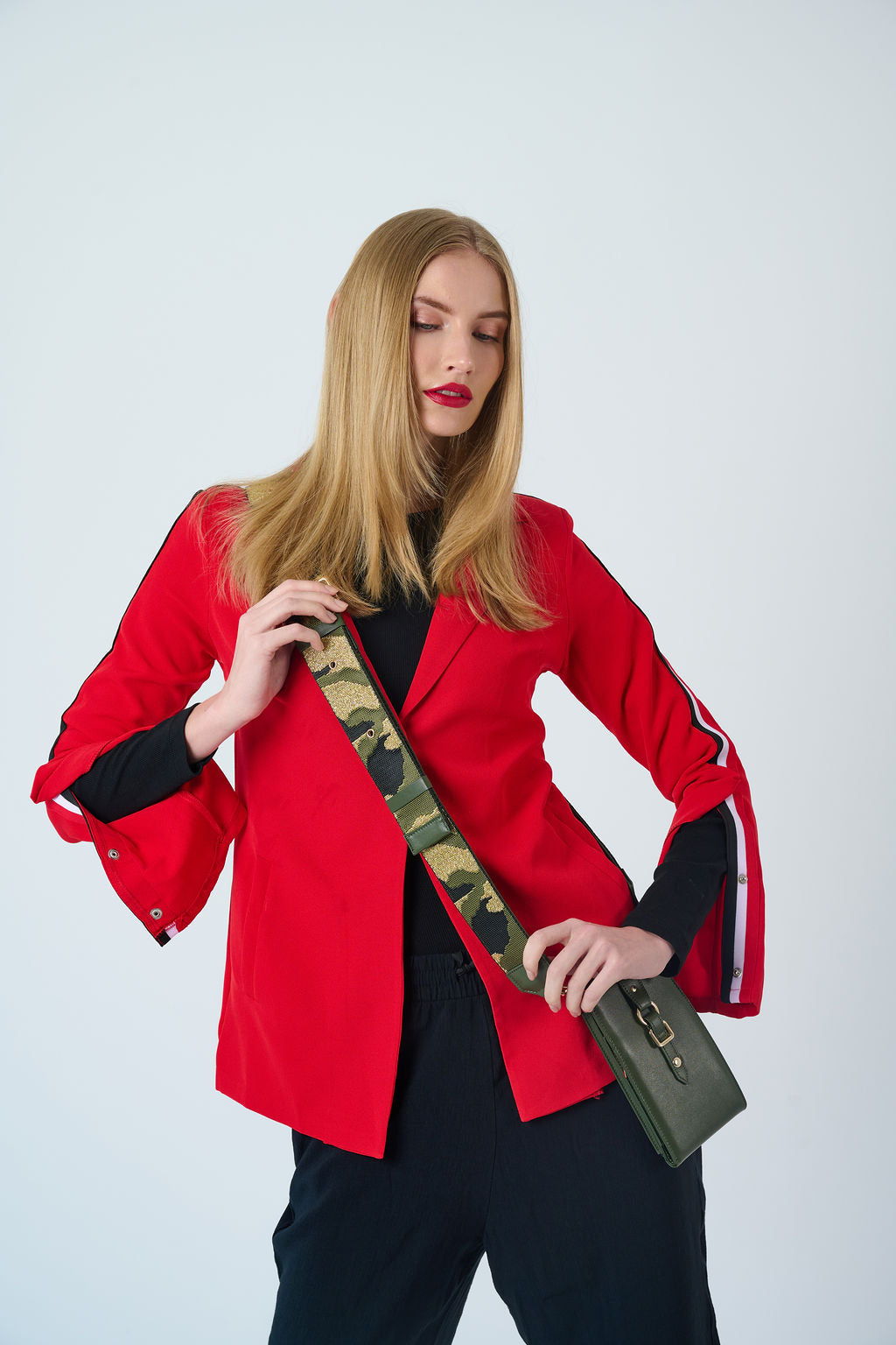 Model wearing CarryOn Wednesday phone wallet bag in army green leather with gold strap.”