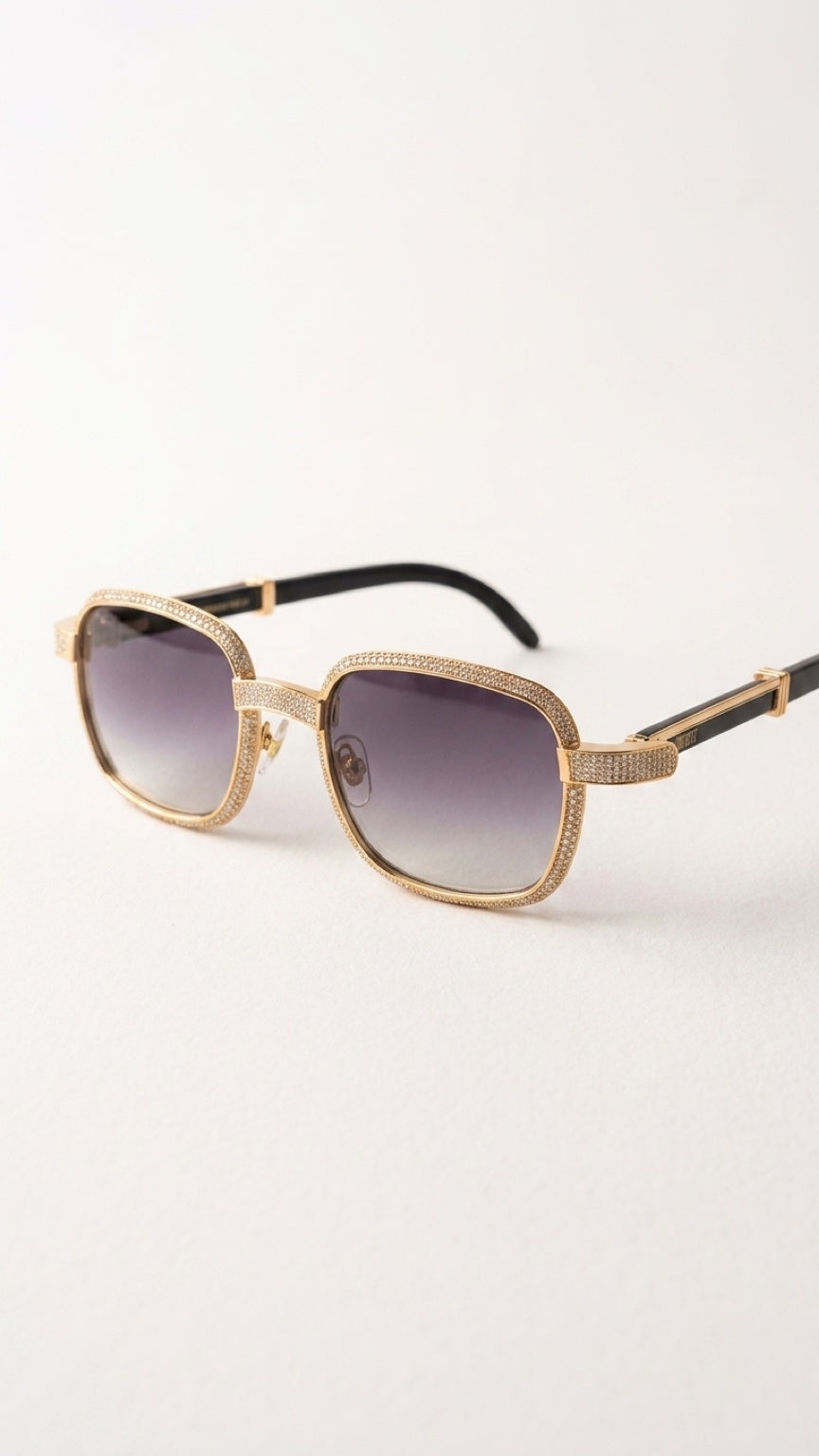 A pair of square-frame sunglasses with a textured gold-tone metal frame, gradient purple lenses, and black temple arms, shown on a clean white background.